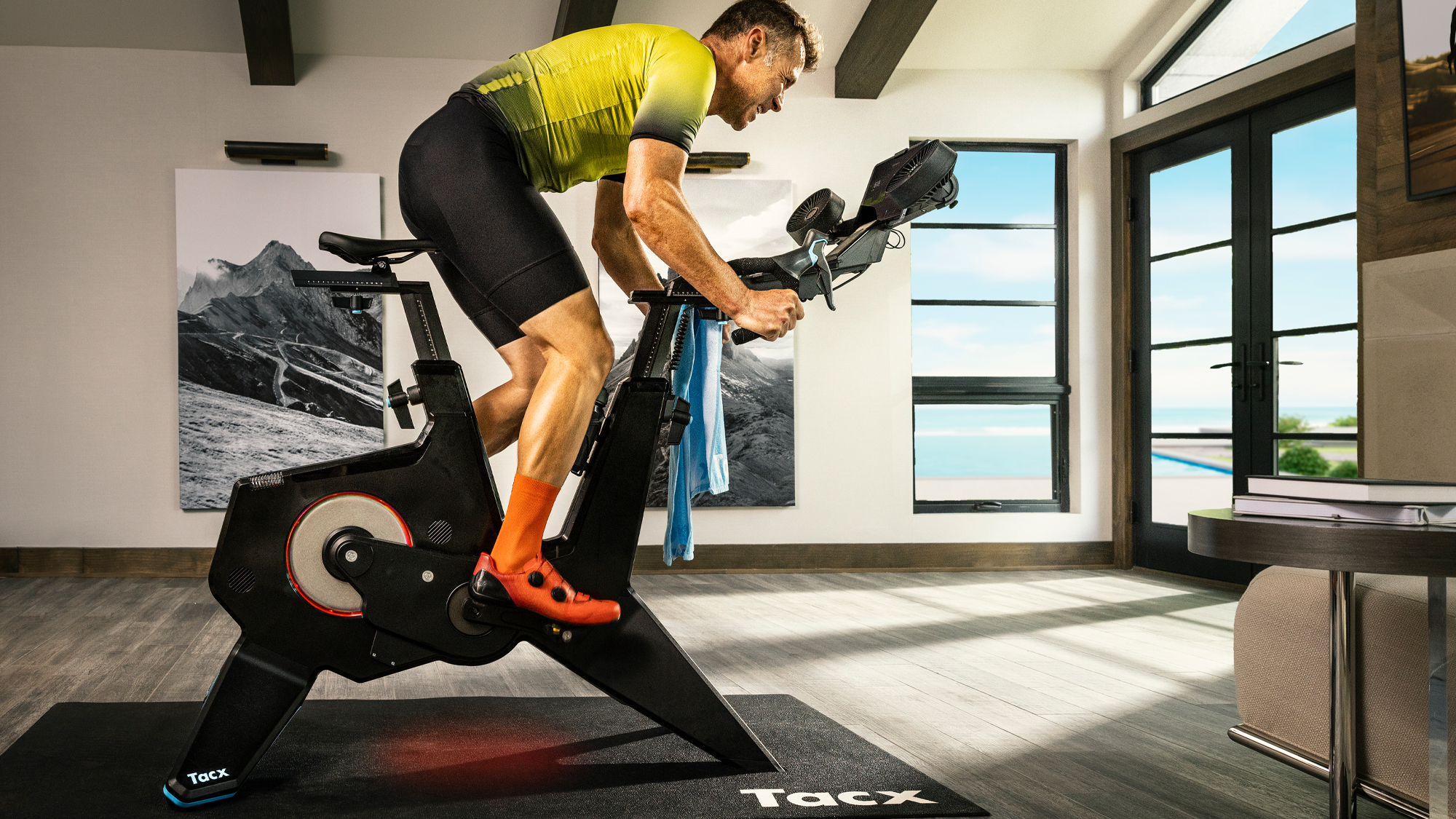 Un hombre montando una de las mejores bicicletas inteligentes en interiores, la Garmin Tacx Neo Bike Plus