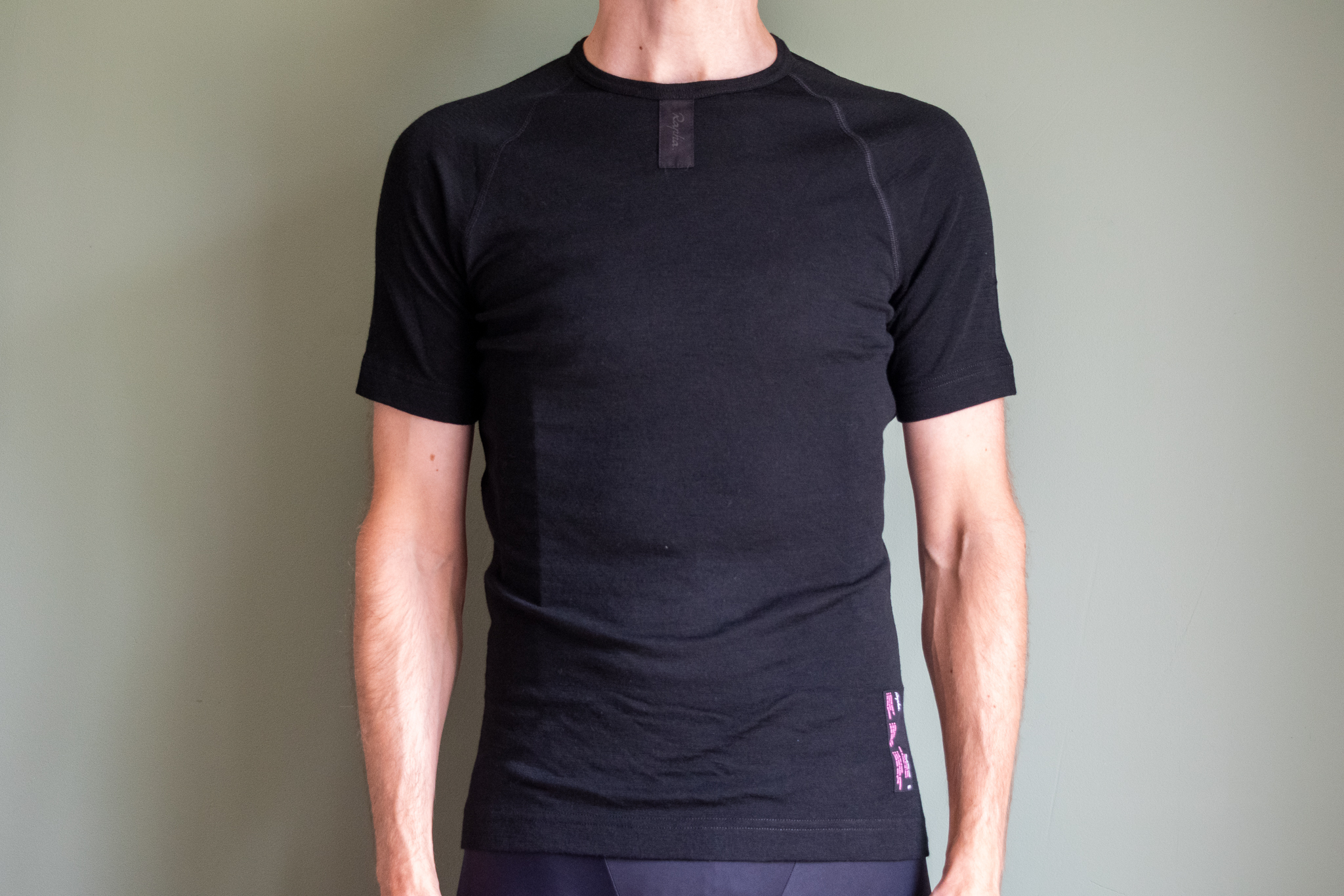 Un hombre que lleva una capa base negra de merino de Rapha.