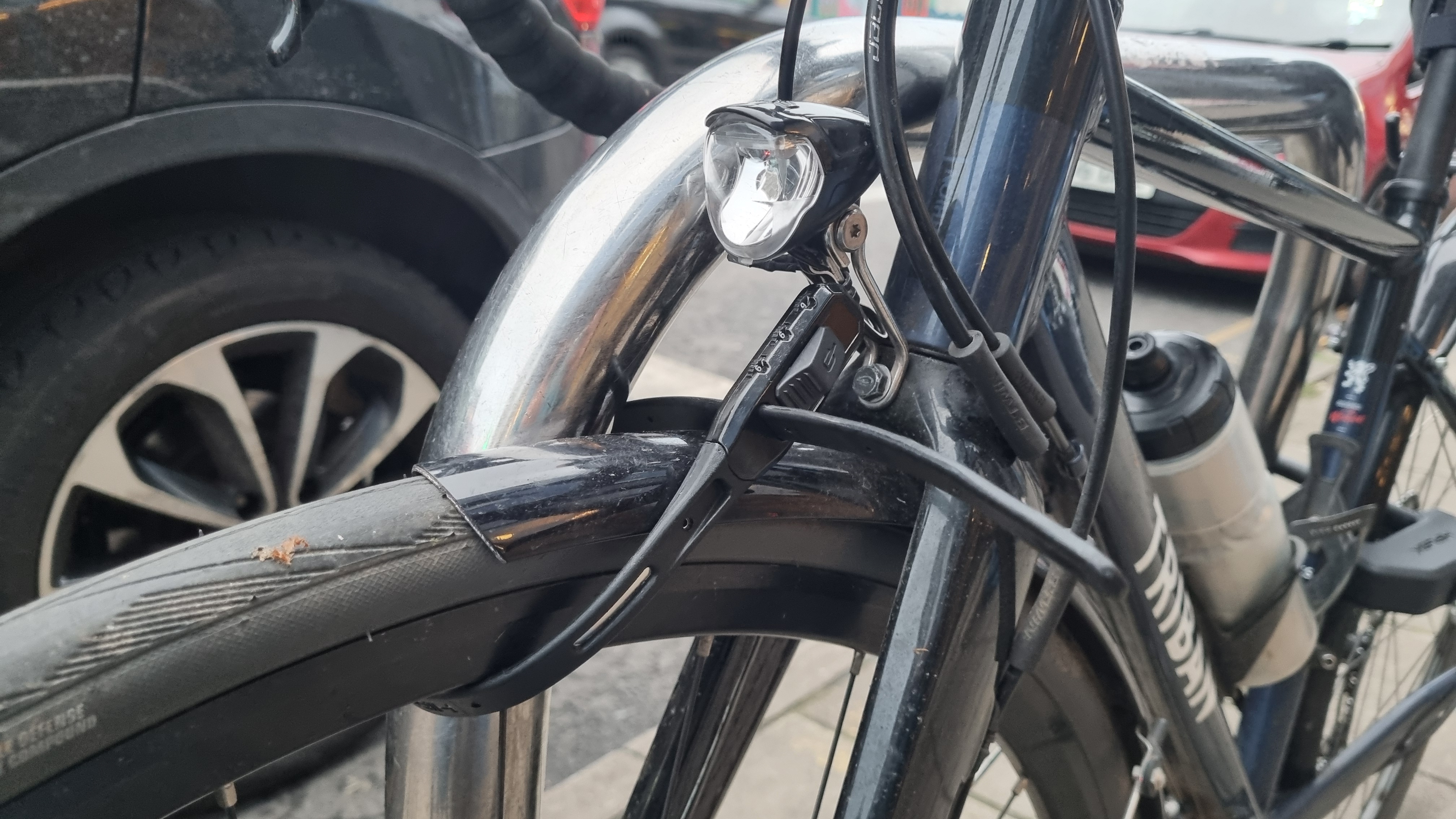 Un combo Hiplok Z Lok que asegura la rueda delantera de una bicicleta de carretera a un puesto de Sheffield