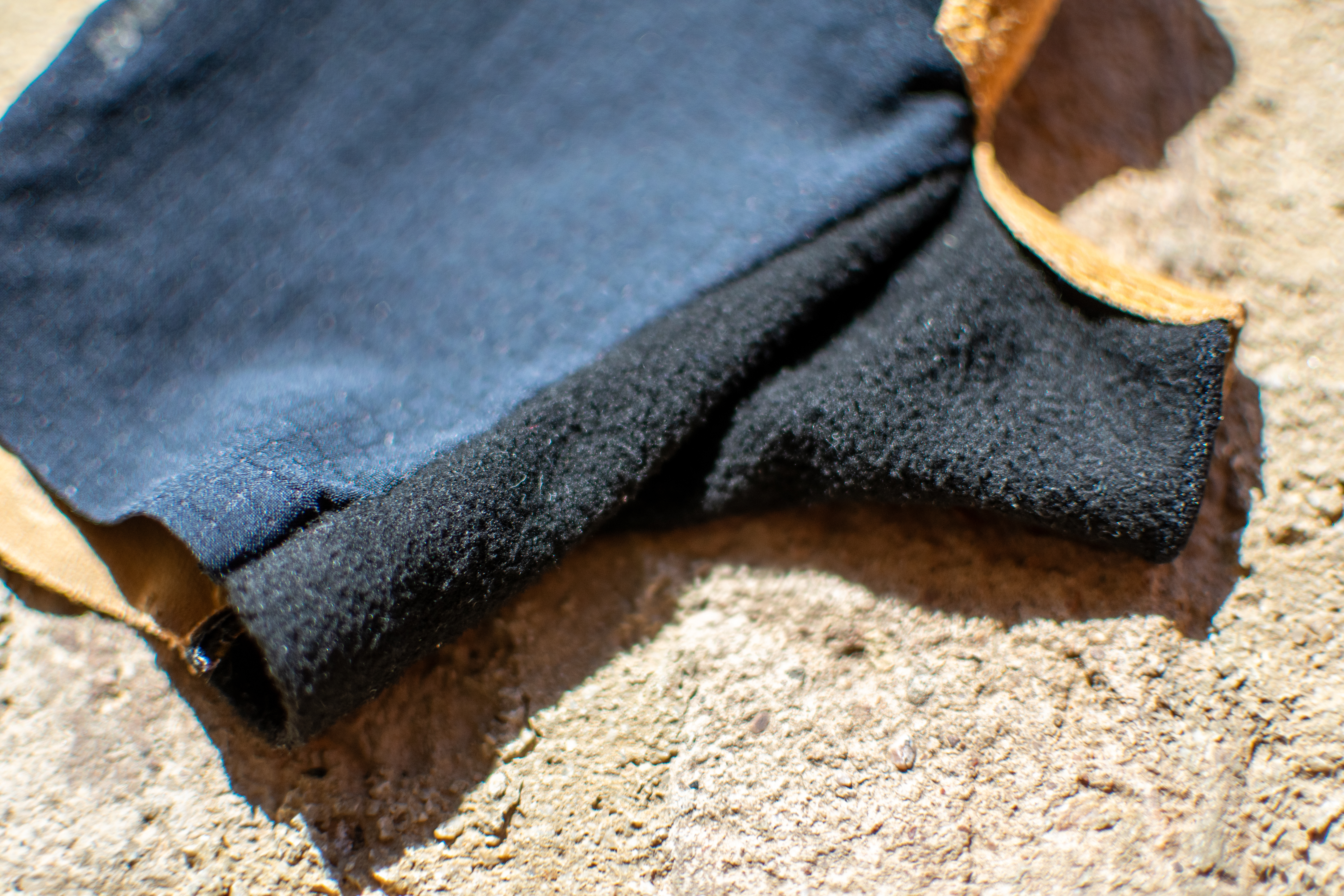 Un par de guantes de aire Pearl Izumi Pro en una pared de ladrillos