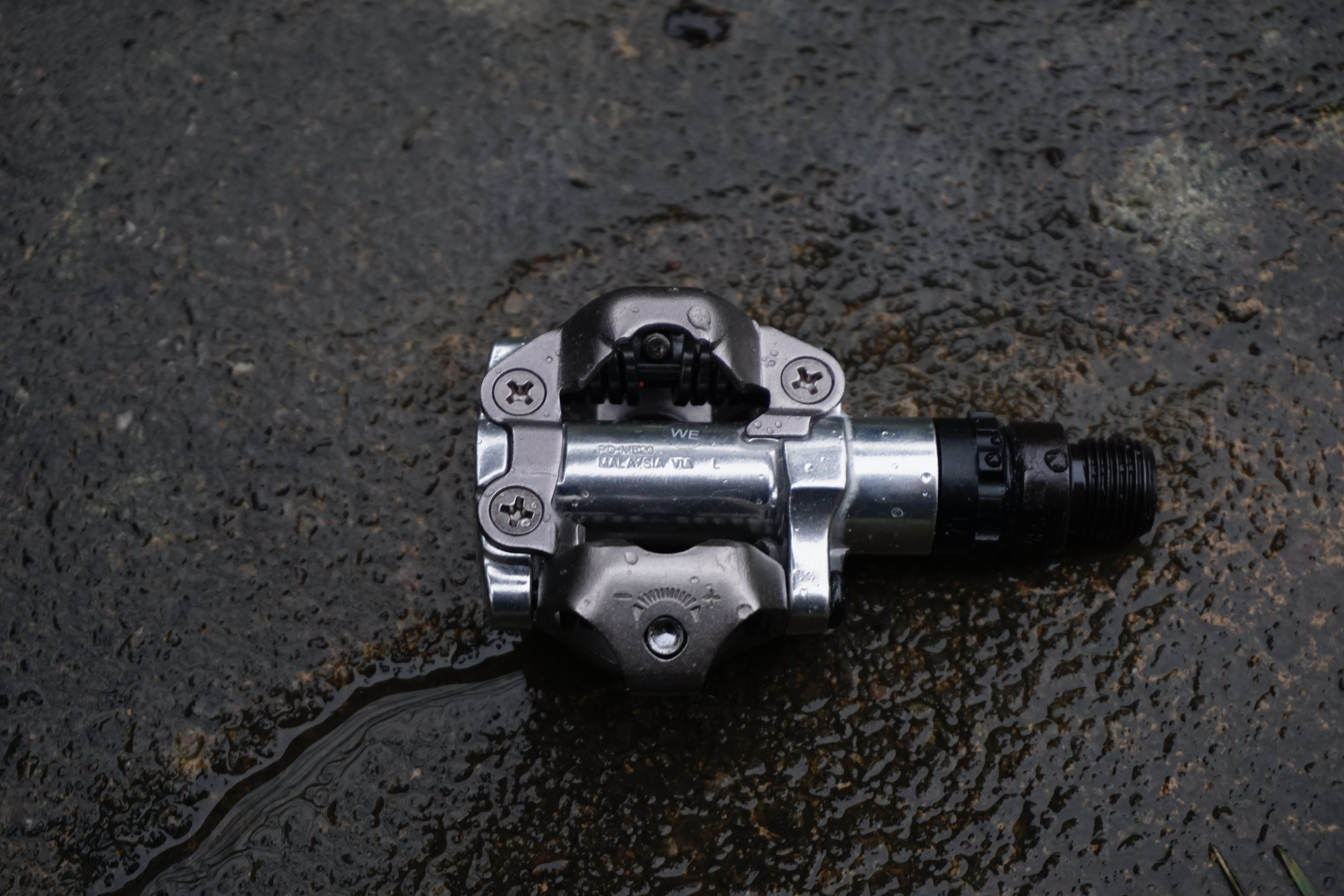 Un primer plano de un pedal de bicicleta de grava plateada