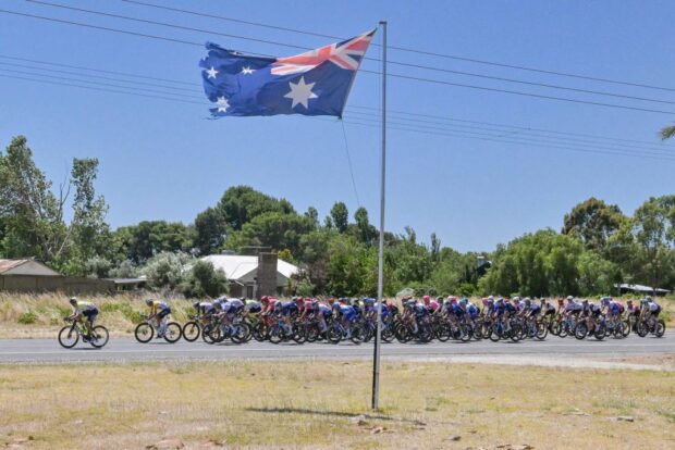 The peloton ride past an Australian flag near McLaren Vale during stage four of the Tour Down Under UCI cycling event in Adelaide on January 21 2023 IMAGE RESTRICTED TO EDITORIAL USE STRICTLY NO COMMERCIAL USE Photo by Brenton EDWARDS AFP IMAGE RESTRICTED TO EDITORIAL USE STRICTLY NO COMMERCIAL USE Photo by BRENTON EDWARDSAFP via Getty Images