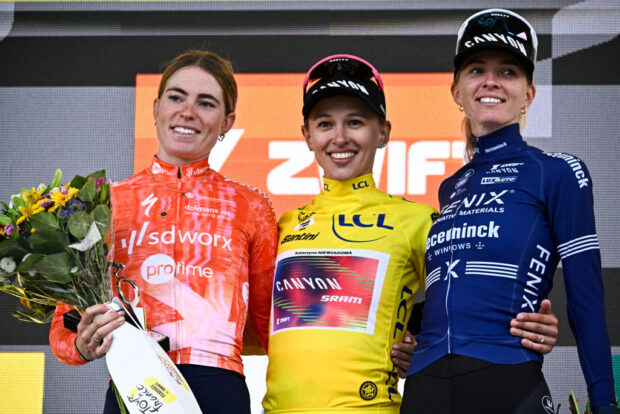 (From L) Stage winner and second placed Team SD Worx - Protime's Dutch rider Demi Vollering, Overalll leader and first placed Canyon//SRAM Racing team's Polish rider Katarzyna Niewiadoma wearing the overall leader's yellow jersey and third placed Fenix-Deceuninck team's Dutch rider Pauliena Rooijakkers celebrate on the podium after competing in the 8th and last stage of the third edition of the Women's Tour de France cycling race, a 149.9 km between Le Grand Bornand and the Alpe d'Huez, in L'Alpe d'Huez, south-eastern France, on August 18, 2024. (Photo by JULIEN DE ROSA / AFP) (Photo by JULIEN DE ROSA/AFP via Getty Images)