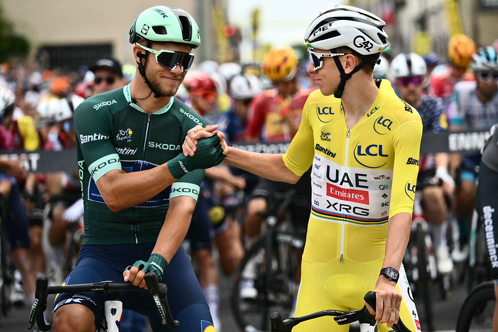Lidl - Trek team's Italian rider Jonathan Milan wearing the best sprinter's green jersey shakes hands with UAE Team Emirates - XRG team's Slovenian rider Tadej Pogacar wearing the overall leader's yellow jersey at the start of the 10th stage of the 112th edition of the Tour de France cycling race, 165.3 km between Ennezat and Le Mont-Dore Puy de Sancy, in central France, on July 14, 2025. (Photo by Marco BERTORELLO / AFP)