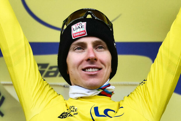 UAE Team Emirates - XRG team's Slovenian rider Tadej Pogacar celebrates on the podium with the overall leader's yellow jersey after the 14th stage of the 112th edition of the Tour de France cycling race, 182.6 km between Pau and Luchon-Superbagneres, in the Pyrenees mountains of southwestern France, on July 19, 2025. (Photo by Marco BERTORELLO / AFP)