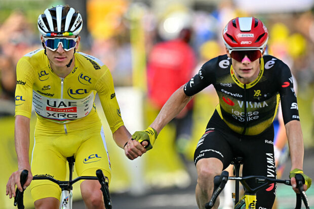 UAE Team Emirates - XRG team's Slovenian rider Tadej Pogacar wearing the overall leader's yellow jersey (L) and Team Visma - Lease a bike team's Danish rider Jonas Vingegaard (R) cross the finish line hand in hand after the 10th stage of the 112th edition of the Tour de France cycling race, 165.3 km between Ennezat and Le Mont-Dore Puy de Sancy, in central France, on July 14, 2025. (Photo by Loic VENANCE / AFP)