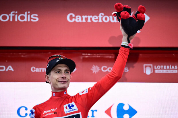 Team Visma-Lease a bike's Danish rider Jonas Vingegaard, wearing the overall leader's red jersey, celebrates on the podium after winning the second stage of the Vuelta a Espana, a 159,6 km race between Alba and Limone Piemonte, in Italy's Piemonte region, on August 24, 2025. (Photo by Marco BERTORELLO / AFP)
