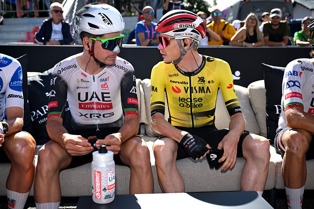 João Almeida y Jonas Vingegaard se sientan en un banco uno al lado del otro hablando antes de la etapa 7 de la Vuelta a Espana