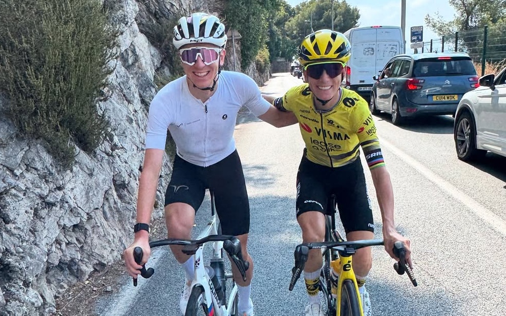 A photo of Tadej Pogačar and Pauline Ferrand-Prévot cycling together, with their arms round each other and smiling