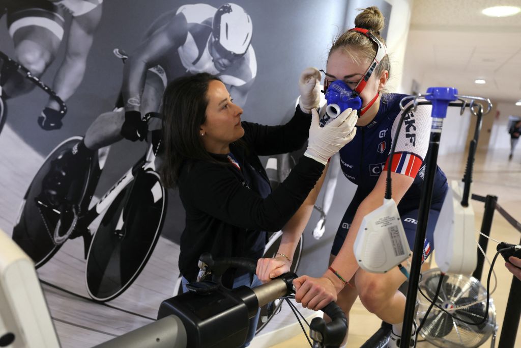 La ciclista francesa Lara Lallemant (R) participa en una sesión de entrenamiento con una científica deportiva de la Federación de Ciclismo, la francesa Iris Sachet, mientras estudia su perfil fisiológico, para alimentar la investigación sobre atletas de alto rendimiento y preparar a los atletas franceses para los Juegos Olímpicos de 2024 en París, en el Velódromo Nacional Francés de Saint-Quentin-en-Yvelines el 31 de enero de 2024. Perfiles de atletas, escaneos 3D del velódromo, Maniquíes gemelos, inteligencia artificial y ganancias marginales: el ciclismo francés apuesta por las ciencias duras para brillar en los Juegos Olímpicos de París y enfrentarse a los pioneros anglosajones en su propio juego. (Foto de Thomas SAMSON / AFP)