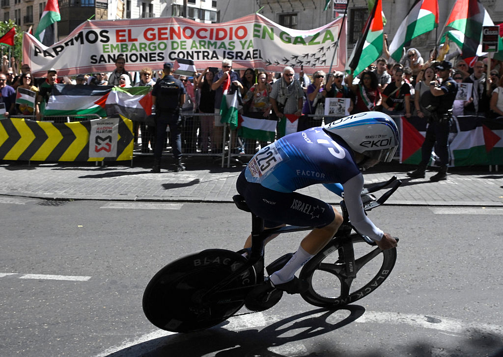 Los manifestantes pro-palestinos ondean las banderas palestinas como el equipo de ISRAEL TECH EQUIPIEL ISRAEL Nadav Raisberg, el jinete israelí Nadav Raisberg compite durante la etapa 18 de la Vuelta a Espana, una carrera de 26 km contra el reloj entre Valladolid y Valladolid, el 11 de septiembre de 2025. (Foto de Miguel Riopa / Afp)