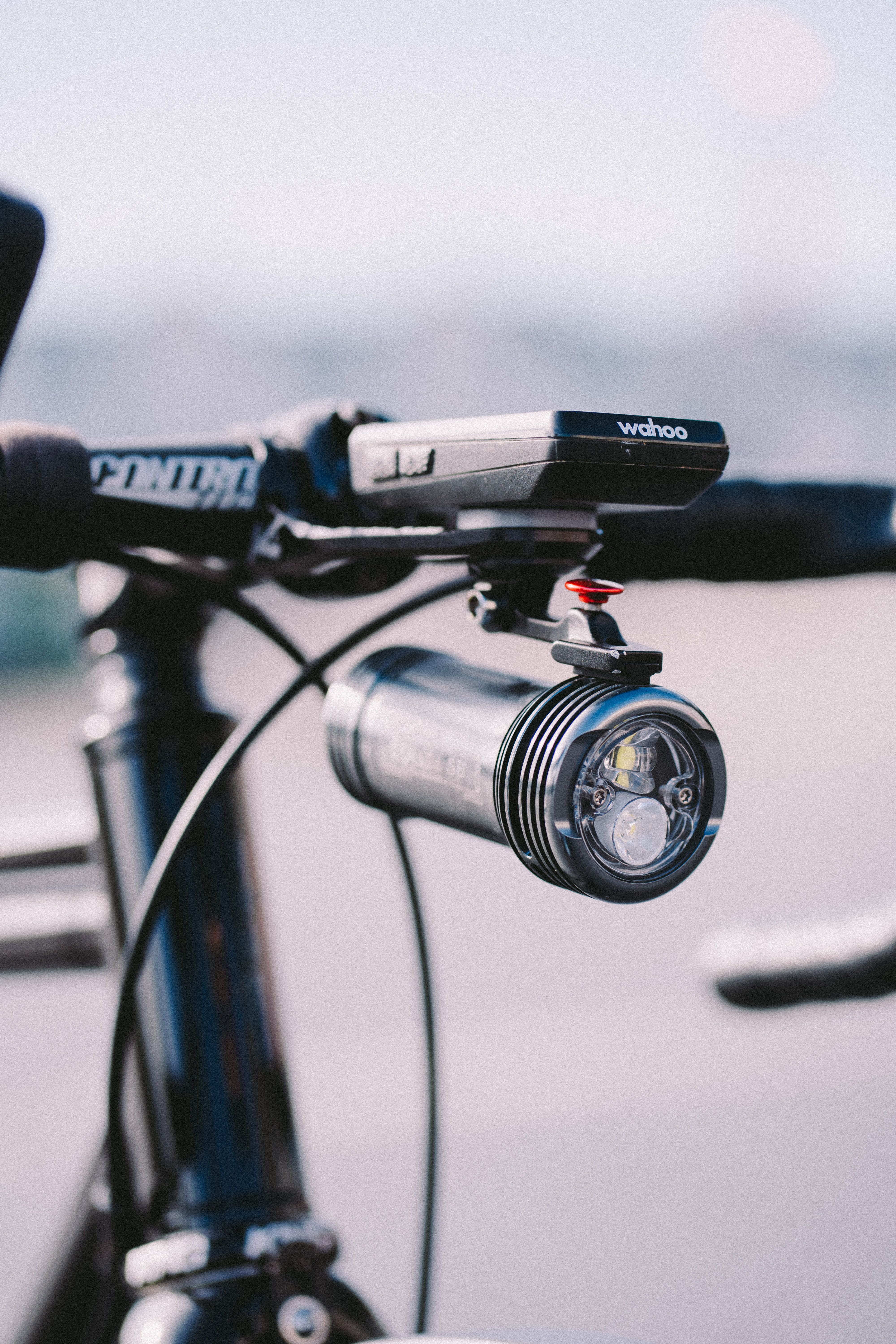 Una gran luz plateada para bicicleta colgada debajo de una computadora para bicicleta