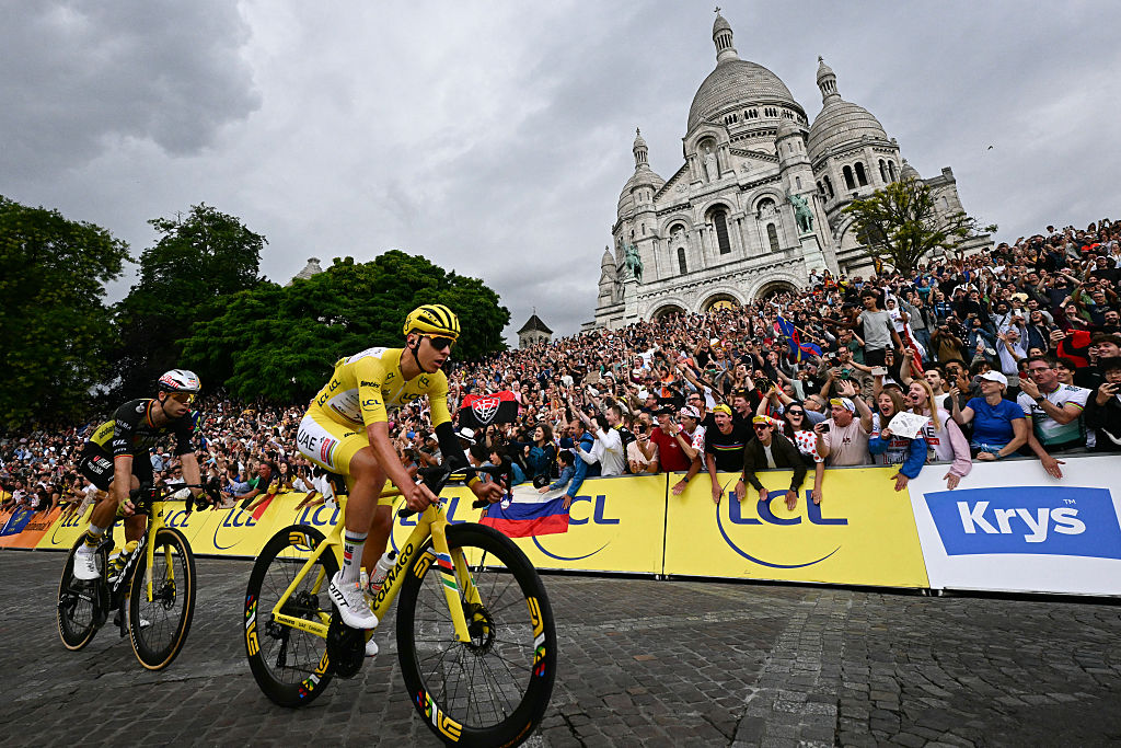UAE Team Emirates - El ciclista esloveno del equipo XRG, Tadej Pogacar, con el maillot amarillo de líder general y el ciclista belga del equipo Visma - Lease a bike's, Wout van Aert, pasa en bicicleta por la Basílica del Sagrado Corazón en la Butte de Montmartre durante la 21.ª y última etapa de la 112.ª edición del Tour de Francia. carrera ciclista, 132,3 km entre Mantes-la-Ville y París' Avenida de los Campos Elíseos, el 27 de julio de 2025. (Foto de Loic VENANCE / AFP)