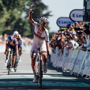 Tadej Pogačar crossing the line celebrating with the Cyclingnews Black Friday logo