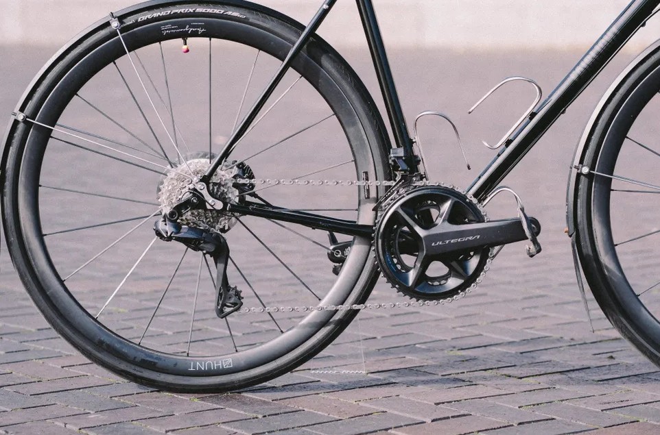 Una bicicleta de carretera negra con guardabarros instalados.