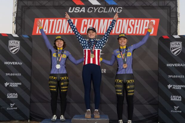 Women's elite podium at 2025 US Cyclocross National Championships in Fayetteville, Arkansas, winner Lizzy Gunsalus (CCB p/b Levine Law Group) surrounded by second-placed Katherine Sarkisov (CXD Trek Bikes) on left and third-placed Alyssa Sarkisov (CXD Trek Bikes) on right