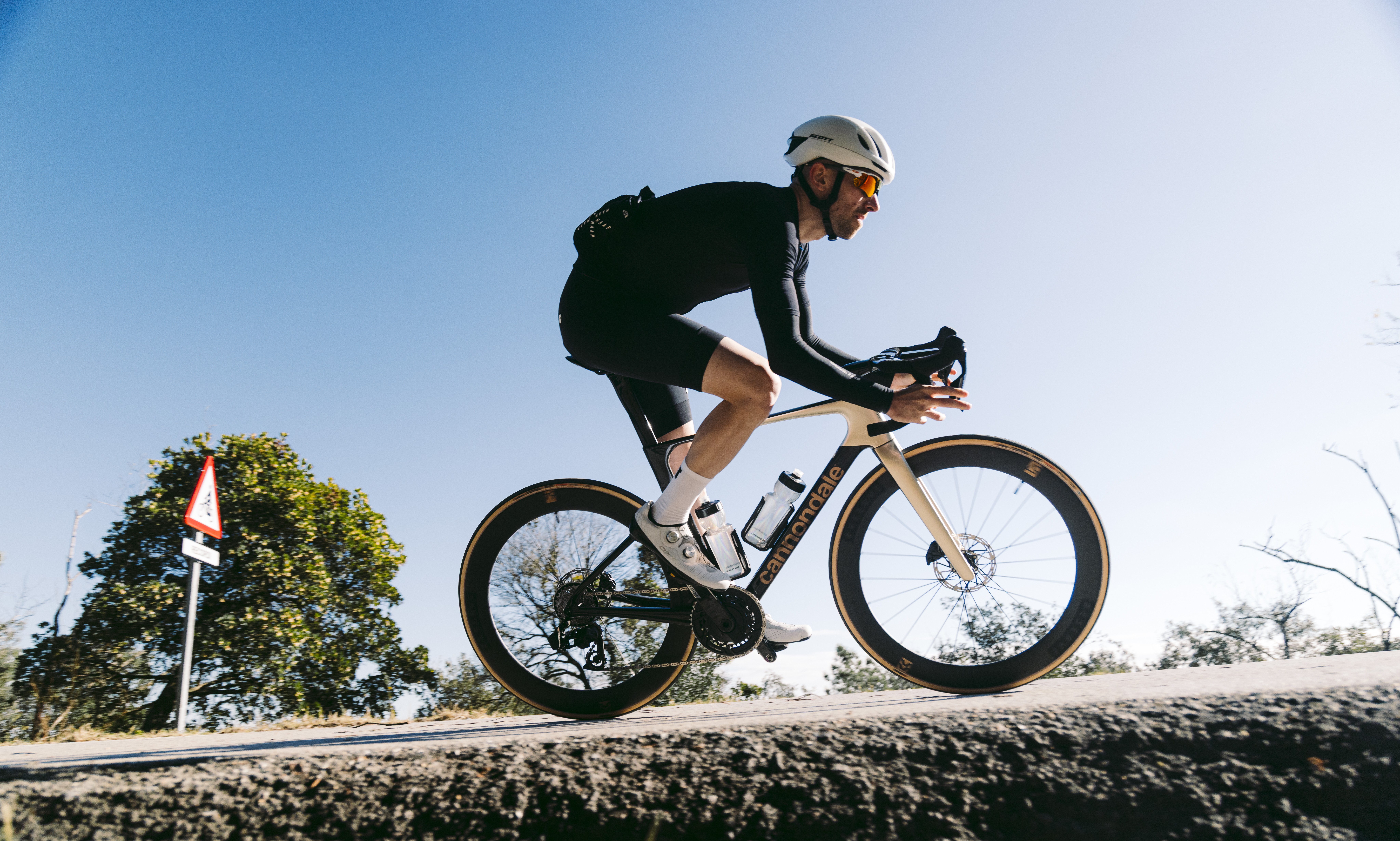Un hombre montado en una Cannondale SuperSix Evo contra un fondo de cielo azul