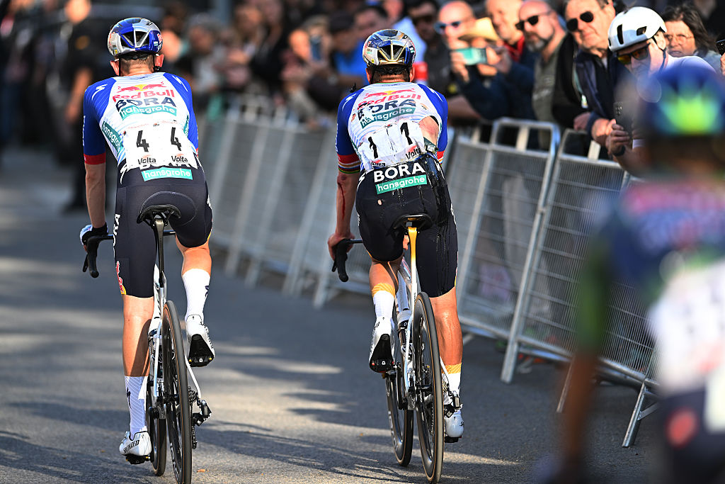 Evenepoel y su compañero de equipo Luke Tuckwell fotografiados desde atrás con lágrimas evidentes en la camiseta de Evenepoel