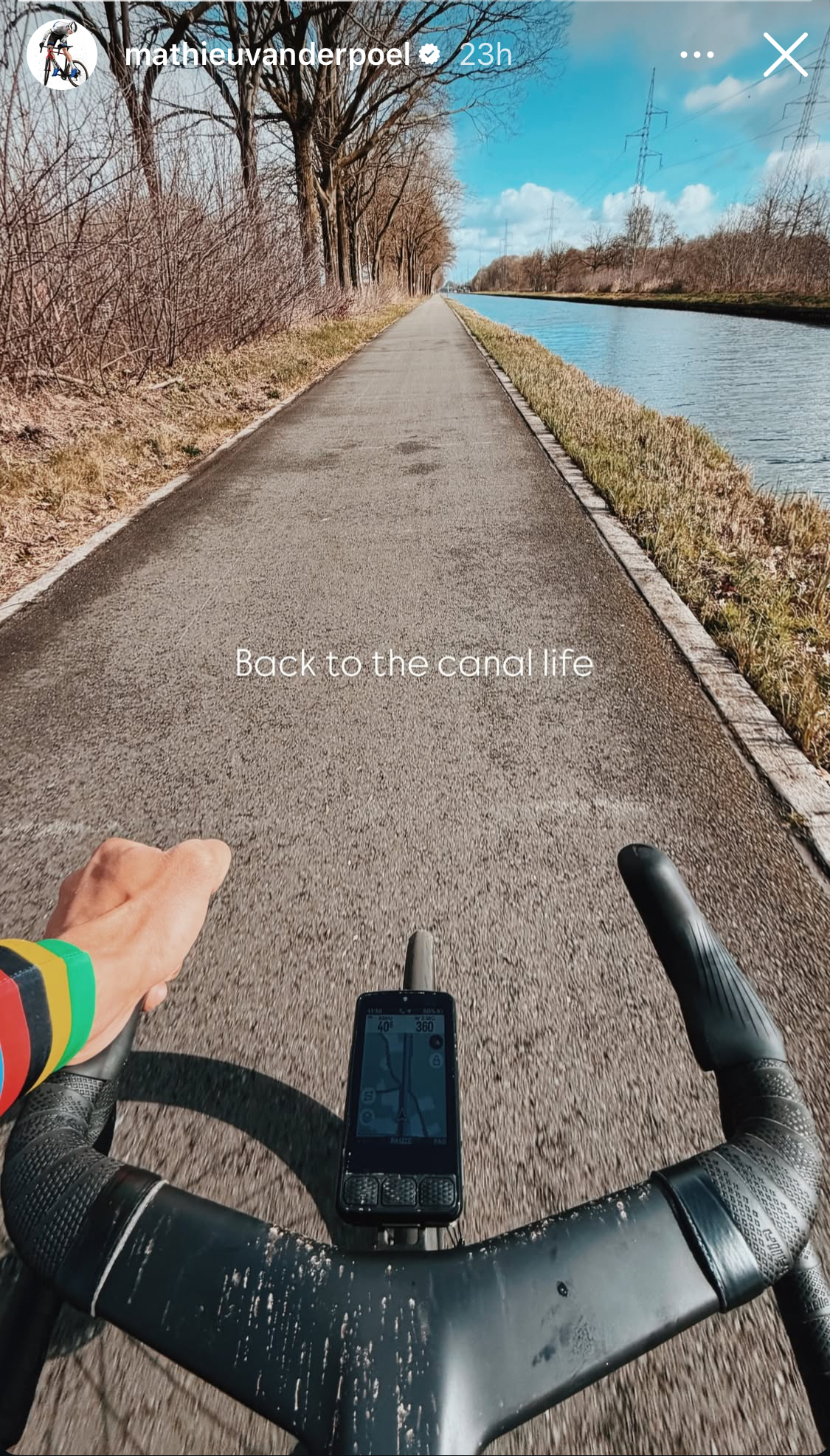 Una imagen de un par de manillares de fibra de carbono en la bicicleta de Mathieu van der Poel mientras recorre un canal.