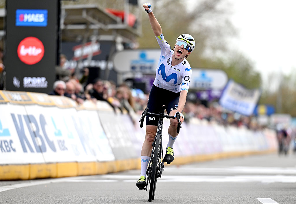 Marlen Reusser con la camiseta blanca con la M azul del Movistar lo celebra con un brazo en alto