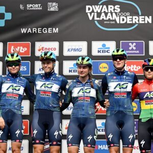 A shot of five AG Insurance-Soudal riders standing on the stage, side by side, at the sign on presentation before Dwars door Vlaanderen 2026
