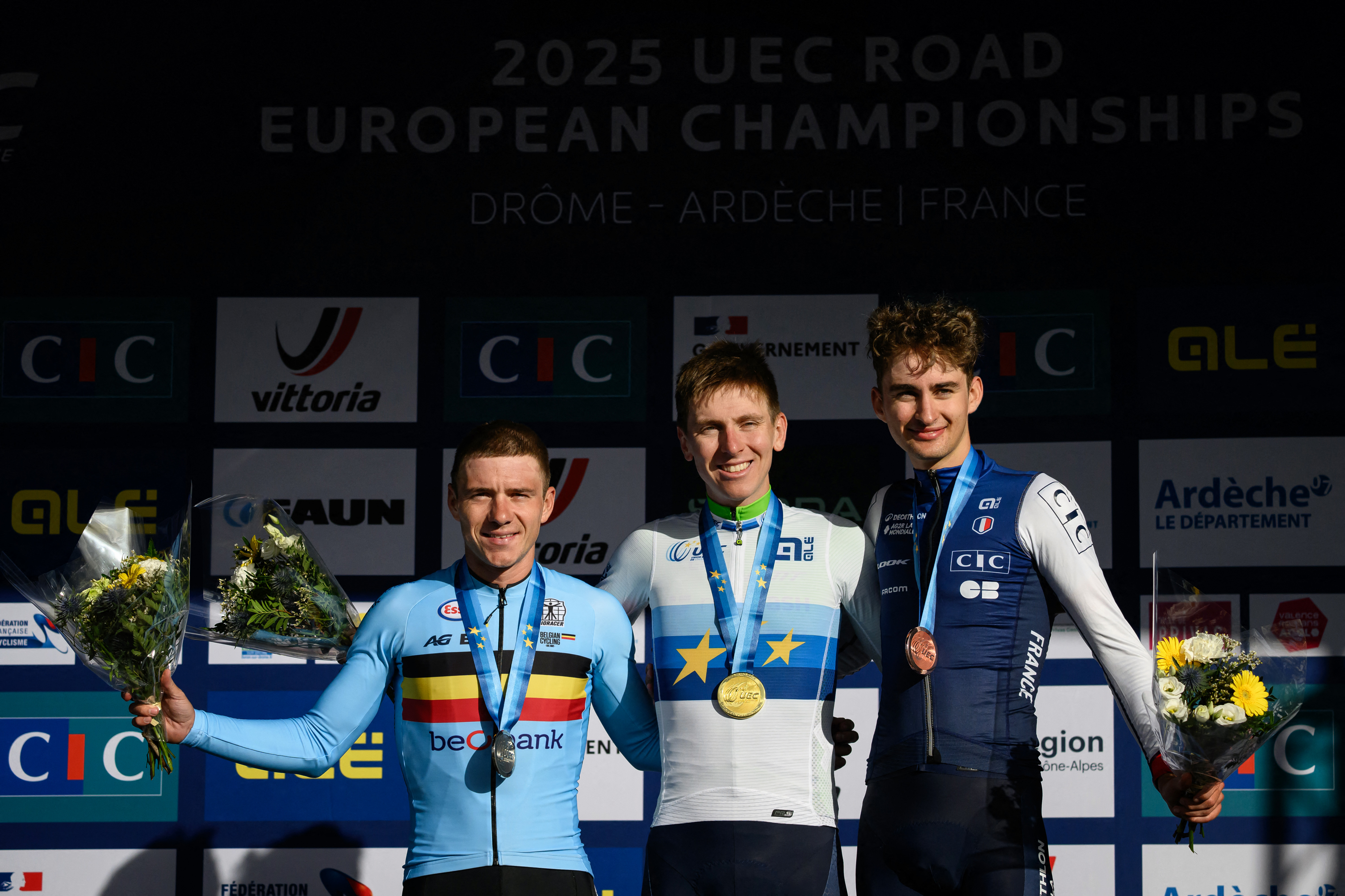 Tadej Pogacar (C), Remco Evenepoel (L) y Paul Seixas (R) en el podio tras la Elite Road Race masculina en el Campeonato Europeo de Ciclismo 2025