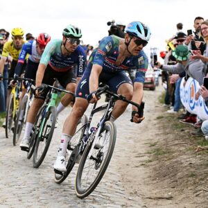 Jasper Stuyven leads a chasing group around a dusty, cobbled corner during Paris-Roubaix 2026