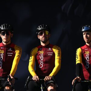 Three Cofidis riders against a moody, dark background