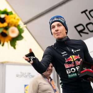 Second placed Red Bull BORA hansgrohe's German Florian Lipowitz, throws flowers during the podium ceremony of the final stage of the Tour of Romandie UCI cycling World tour, 178.2 km from Lucens and to Leysin, in Leysin, Switzerland, on May, 3, 2026. (Photo by TIL BUERGY / AFP via Getty Images)