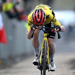 Vingegaard kisses a photo of his family on his handlebars after winning the stage