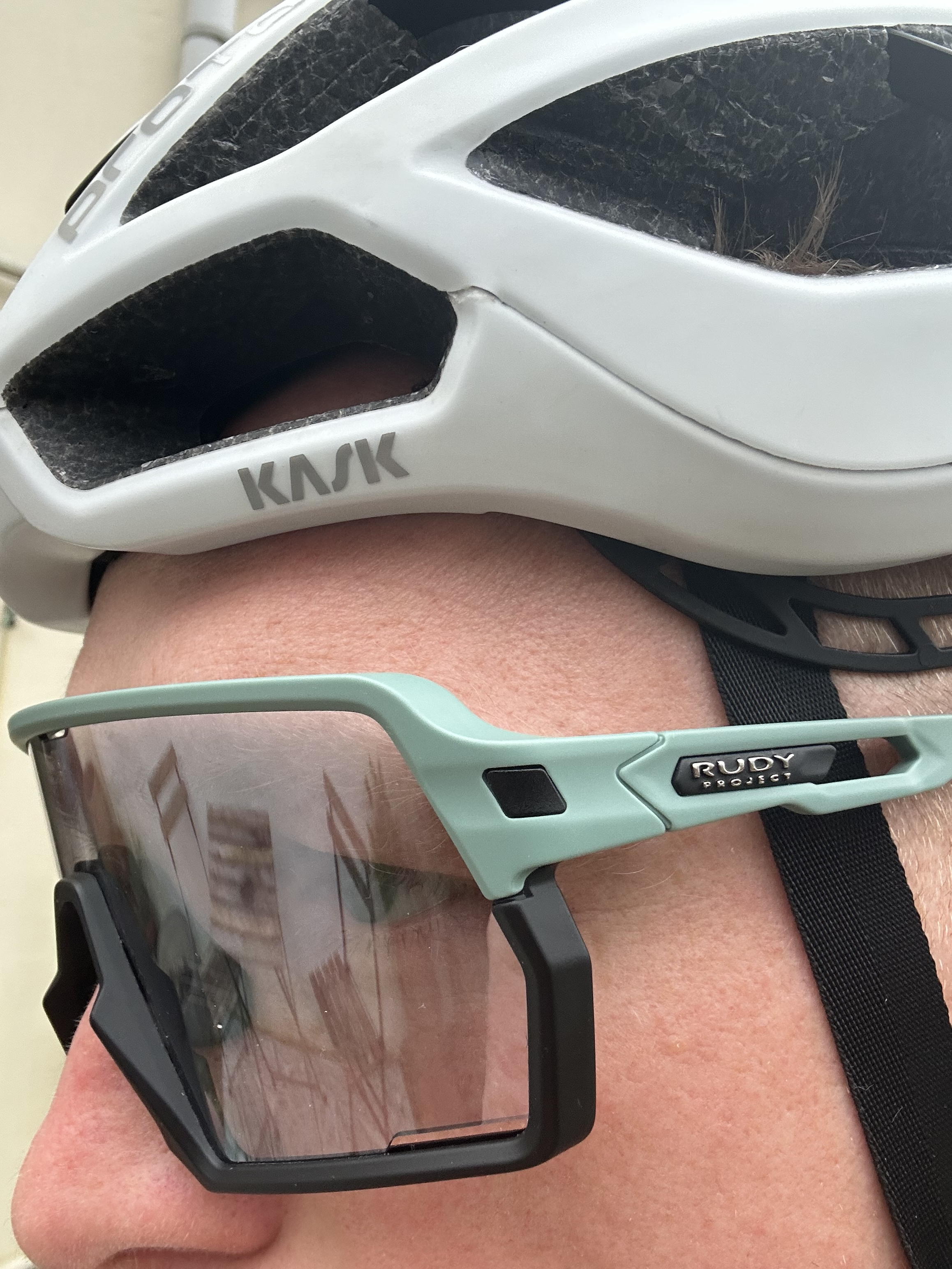 Un hombre lleva gafas de sol debajo de un casco de bicicleta.