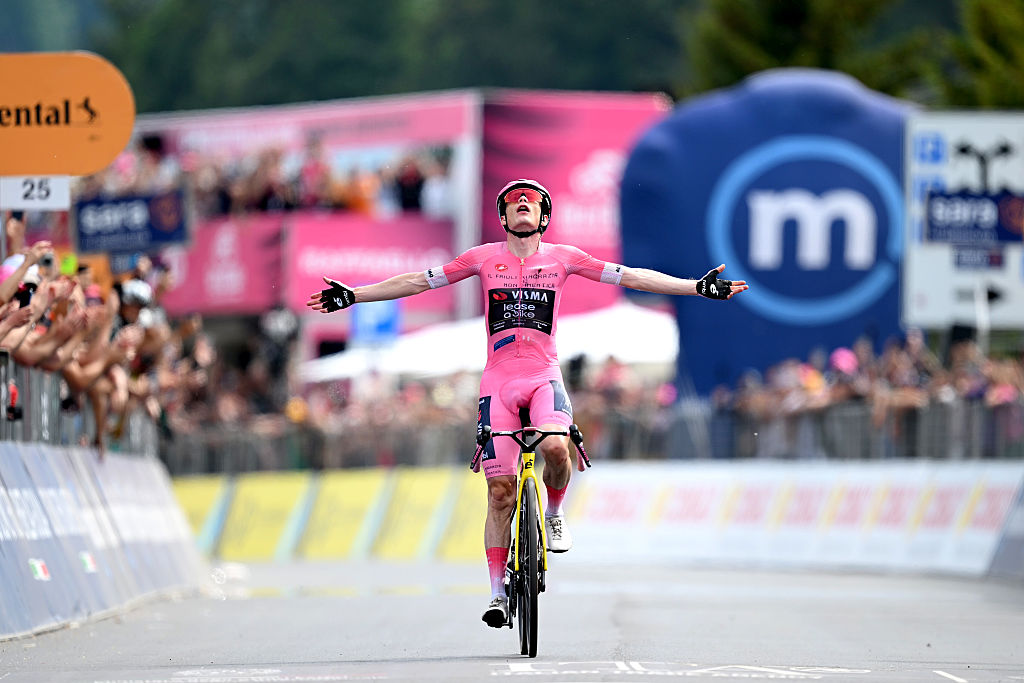 Vingegaard celebra con ambos brazos extendidos con la maglia rosa tras ganar la etapa 20 del Giro de Italia