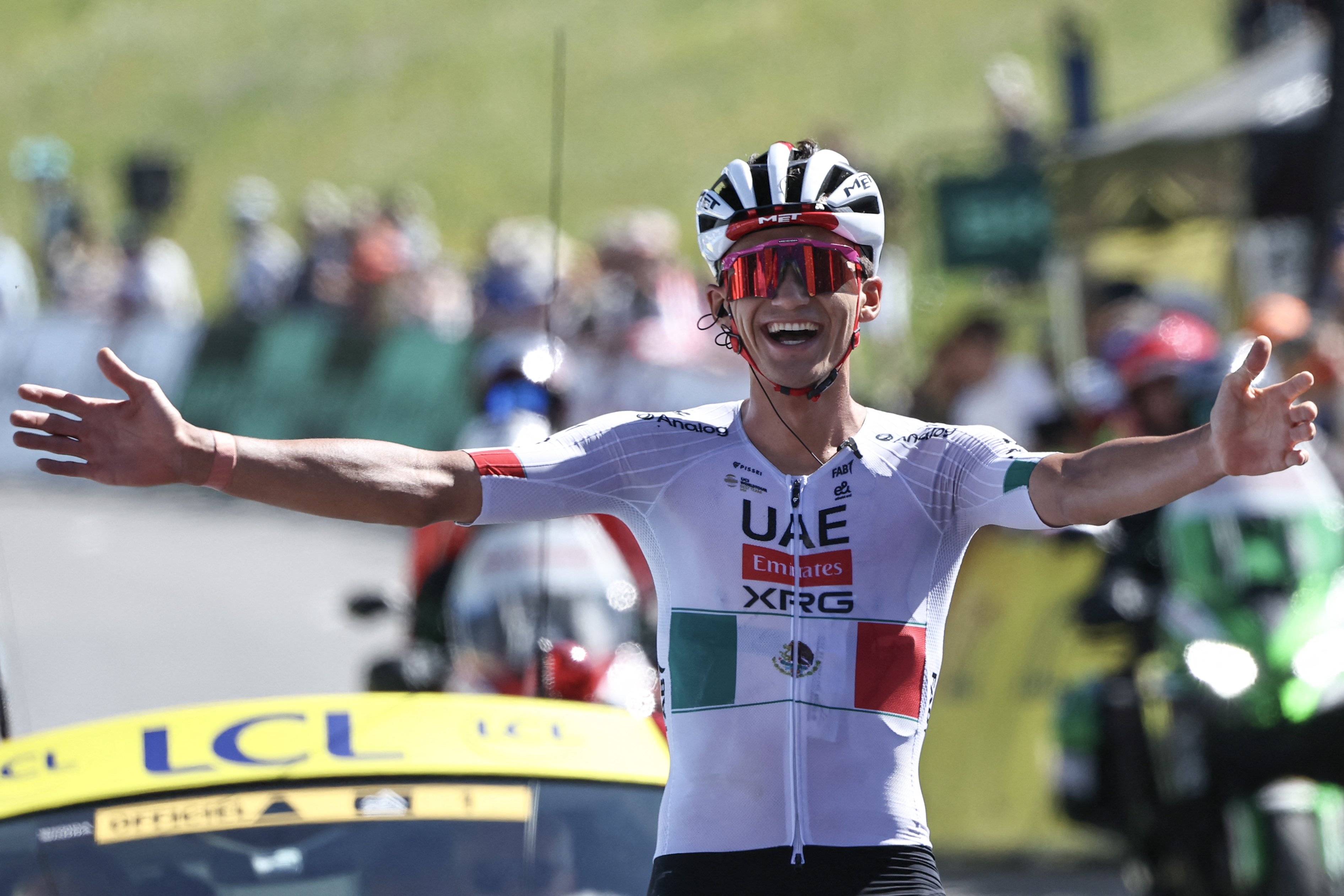 El ciclista mexicano del UAE Team Emirates XRG, Isaac Del Toro Romero, celebra mientras llega a la línea de meta para ganar la octava y última etapa de la carrera ciclista Tour Auvernia-Ródano-Alpes (anteriormente conocida como Criterium du Dauphine), 120,1 km entre Beaufort y Plateau de Solaison, en los Alpes franceses el 14 de junio de 2026. (Foto de Anne-Christine POUJOULAT / AFP)