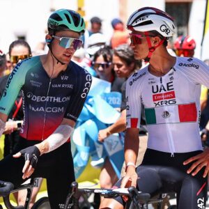 Paul Seixas (L) and Isaac Del Toro Romero speak at the start line before the 8th and final stage of the Tour Auvergne-Rhone-Alpes