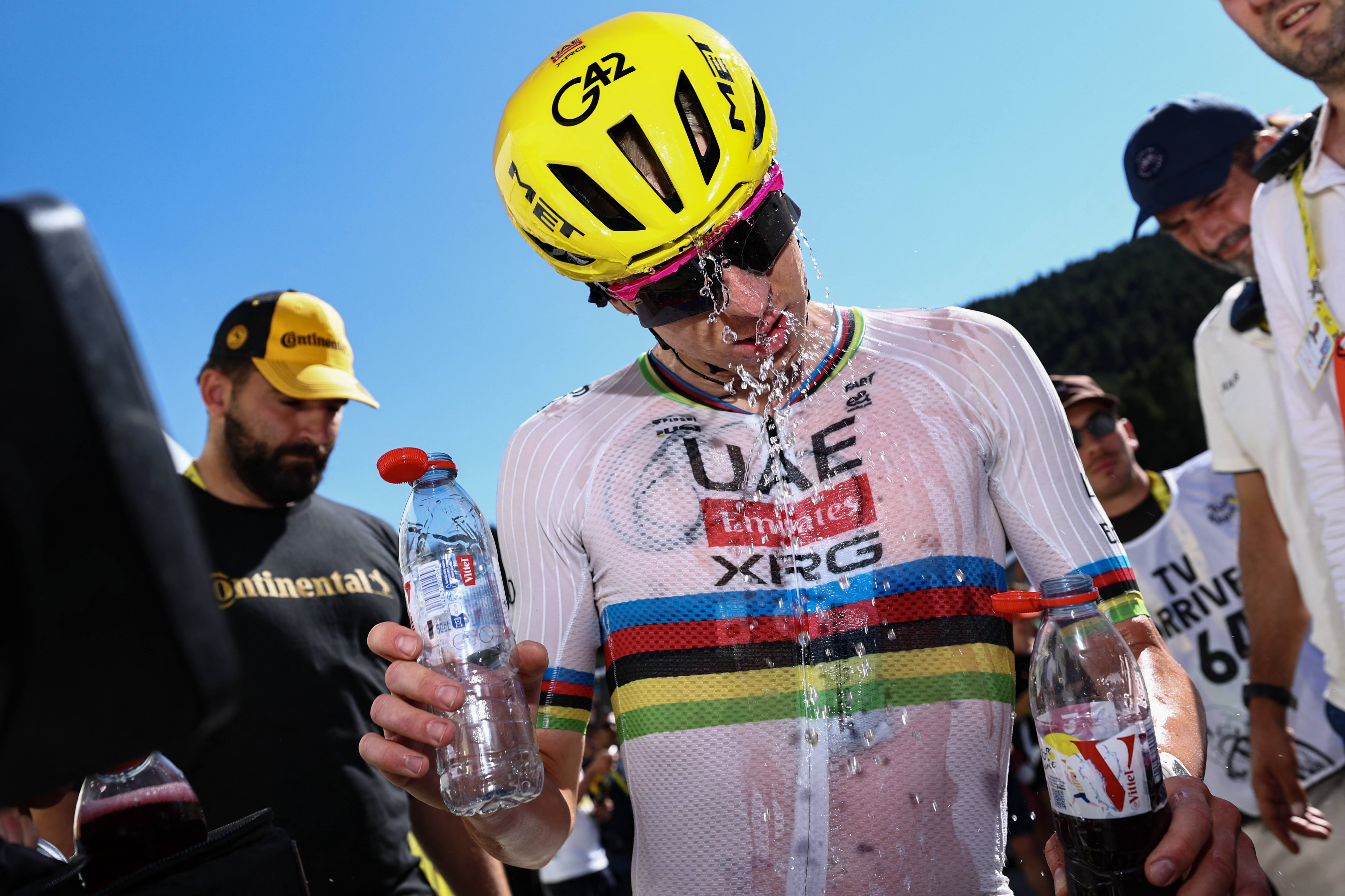 Tadej Pogačar se refresca en el Tour de Francia echándose una botella de agua sobre el casco tras la etapa 3 en Les Angles
