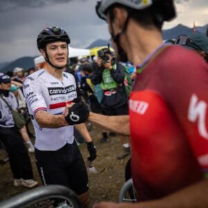 Christopher Blevins (Specialized Factory Racing) shakes hands with Charlie Aldridge after taking third in the short-track at the Pal Arinsal round of the WHOOP UCI Mountain Bike World Series