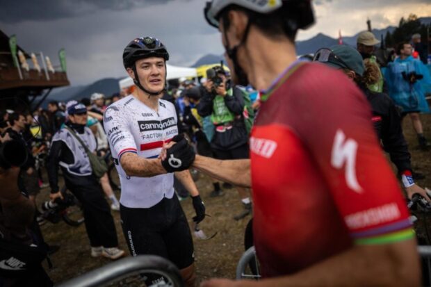Christopher Blevins (Specialized Factory Racing) shakes hands with Charlie Aldridge after taking third in the short-track at the Pal Arinsal round of the WHOOP UCI Mountain Bike World Series