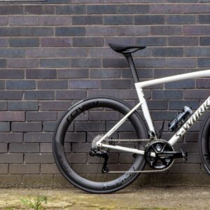 A white Specialized S-Works Tarmac SL8 stands against a wall