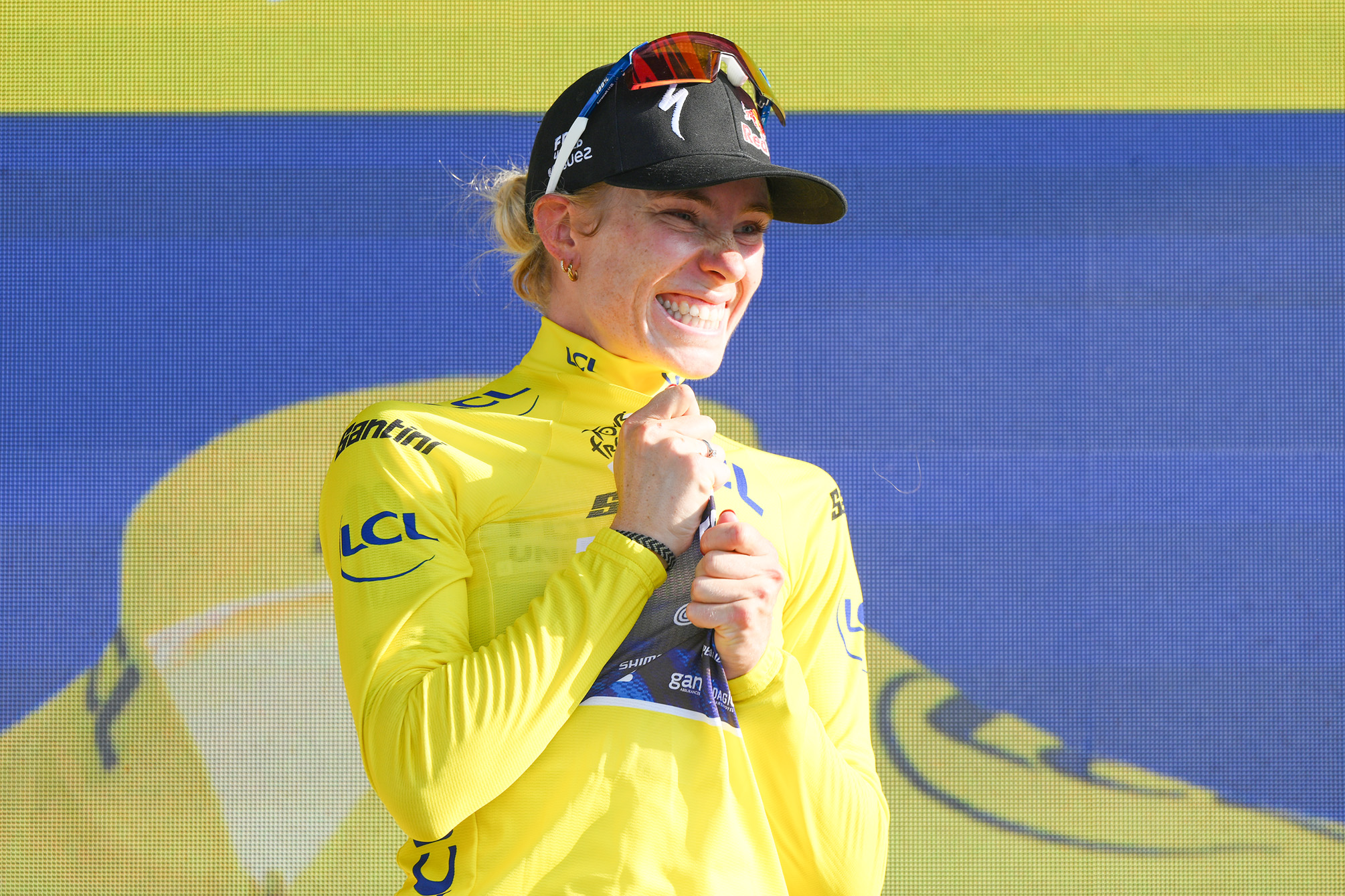 Demi Vollering luciendo el maillot amarillo en el podio