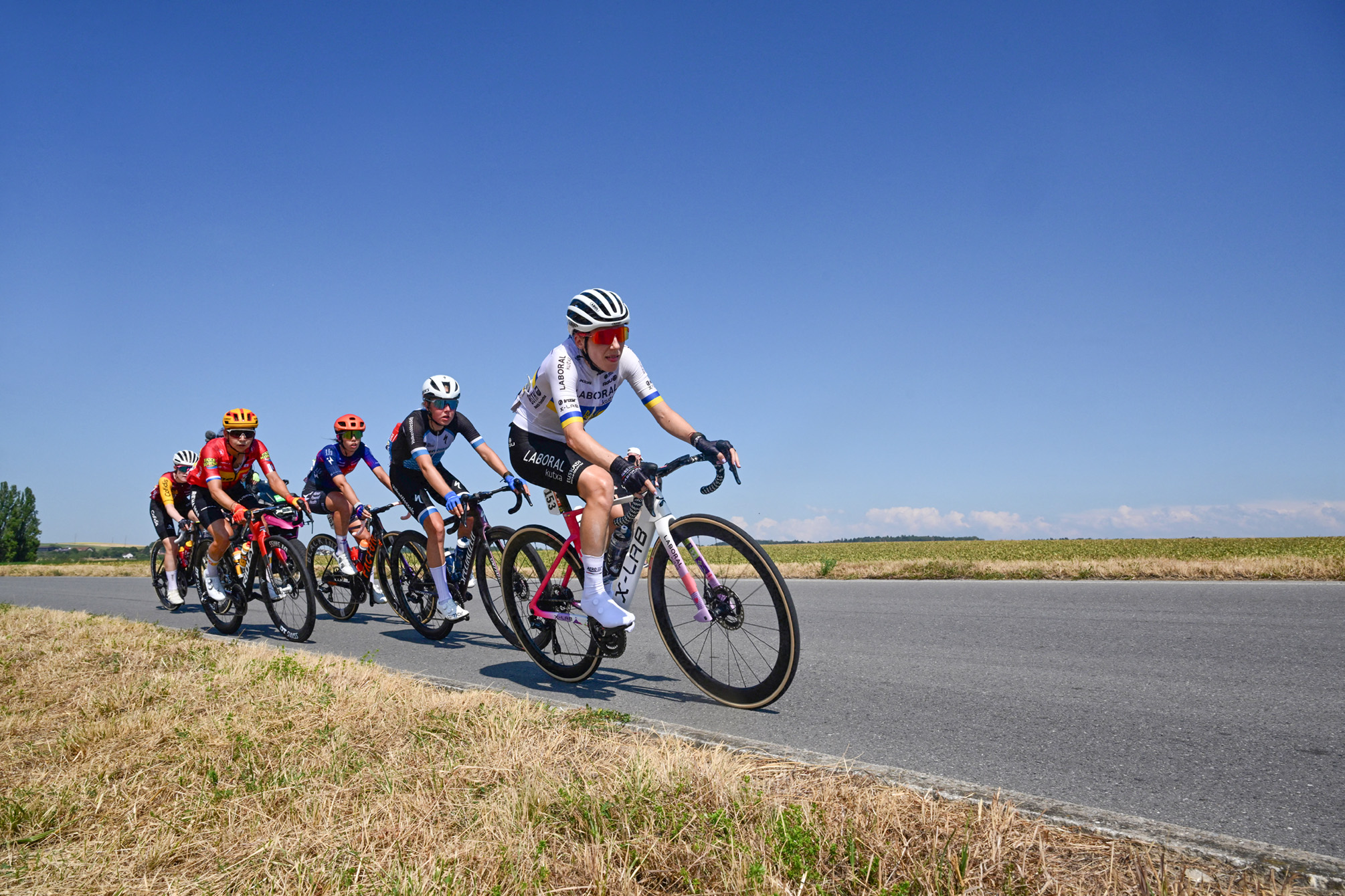 Los ciclistas de una escapada que incluyen a la ciclista ucraniana del Laboral Kutxa-Fundación Euskadi Yuliia Biriukova (derecha), a la ciclista holandesa del equipo ciclista VolkerWessels Eline Jansen (2da a la derecha) y a la ciclista italiana de Human Powered Health Carlotta Cipressi (3a a la derecha) compiten durante la segunda (de 9) etapa de la quinta edición de la carrera ciclista femenina del Tour de Francia. 147,9 km de Aigle a Ginebra, en Aigle el 2 de agosto de 2026. (Foto de Nicolas TUCAT / AFP vía Getty Images)