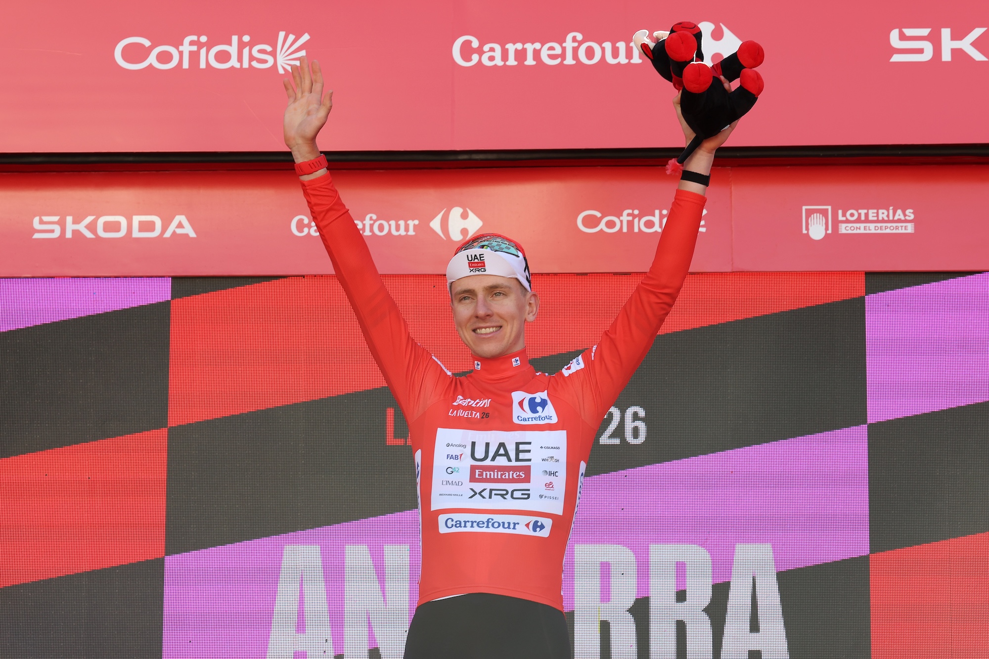 Tadej Pogacar de Eslovenia y el equipo UAE Emirates XRG celebran en el podio como ganador de la camiseta Red Leader durante La Vuelta