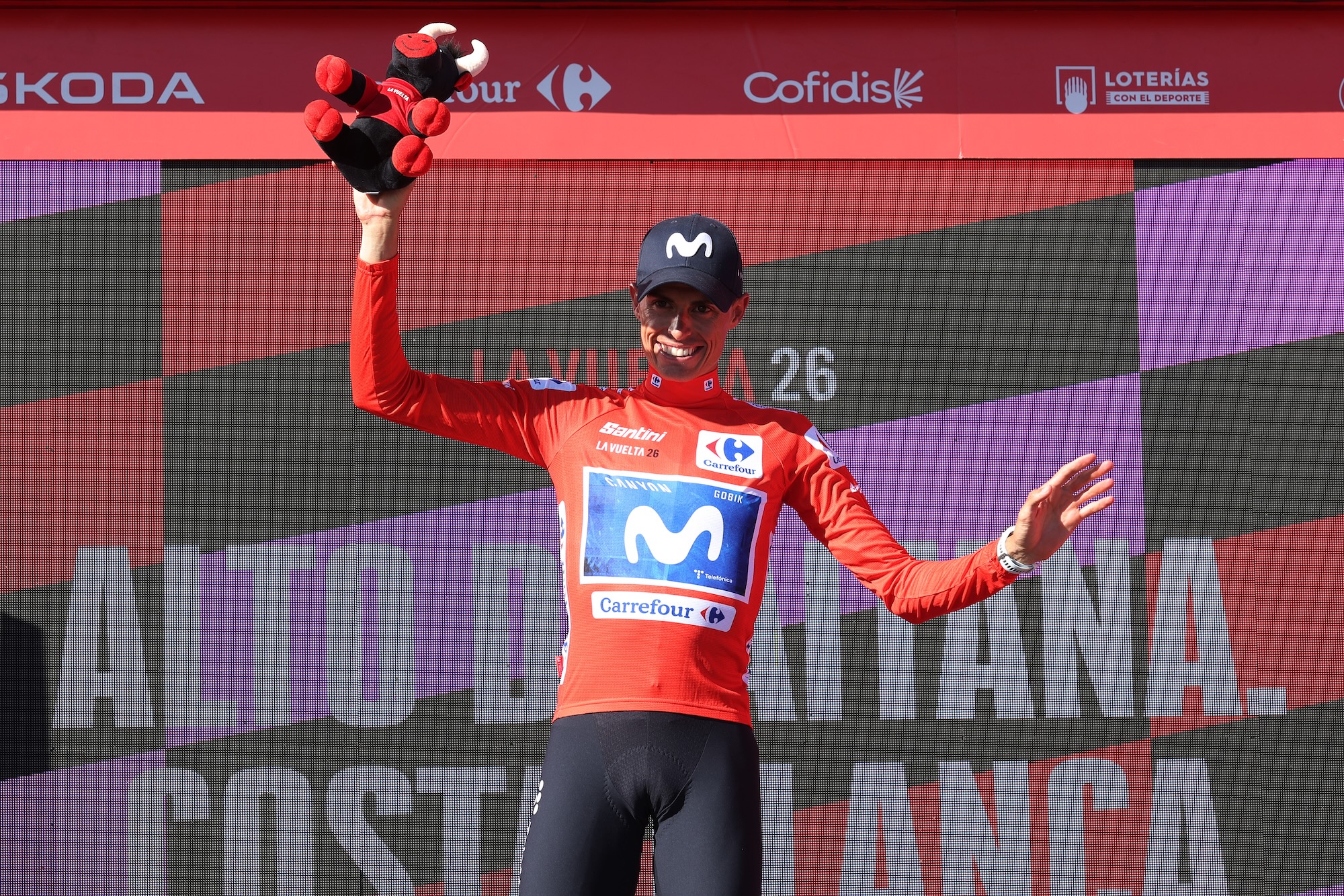 Enric Mas (Movistar) celebra en el podio luciendo el maillot rojo de líder tras la novena etapa