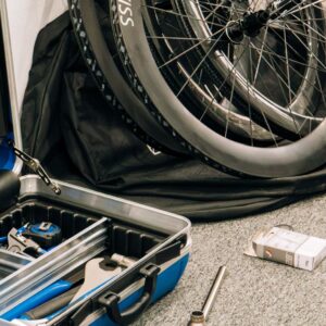 An open toolbox sits next to a pile of road bike wheels
