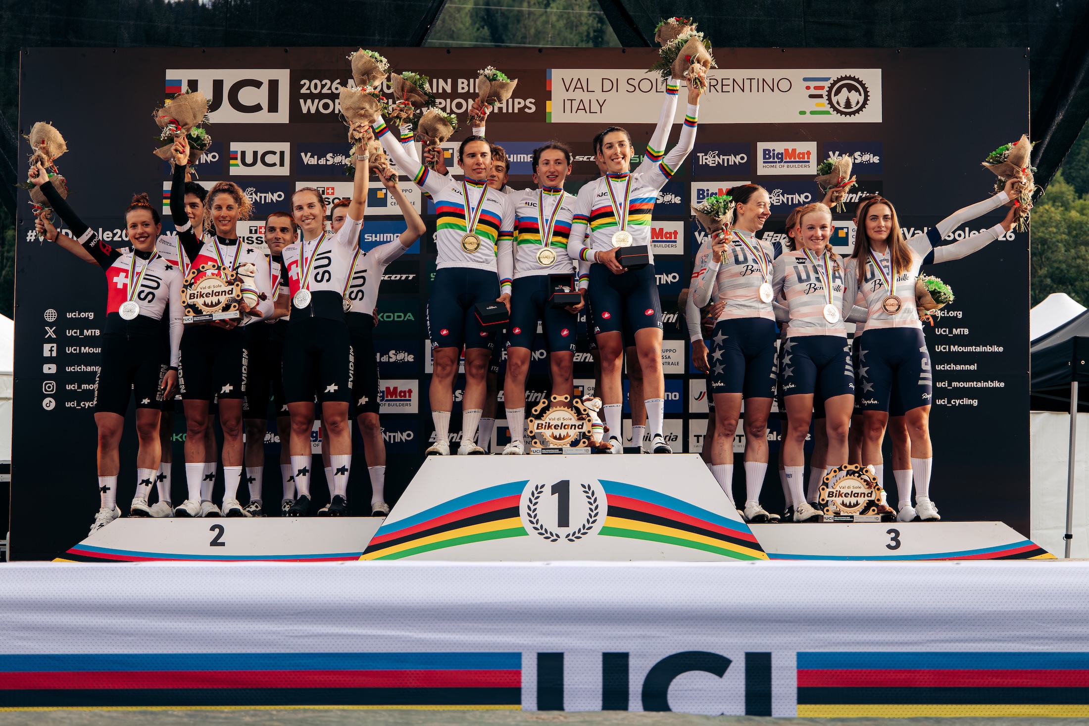 Suiza, la ganadora Italia y el tercer lugar Estados Unidos celebran en el podio luego del relevo por equipos en el Campeonato Mundial de Ciclismo de Montaña UCI 2026 en Val di Sole, Italia.