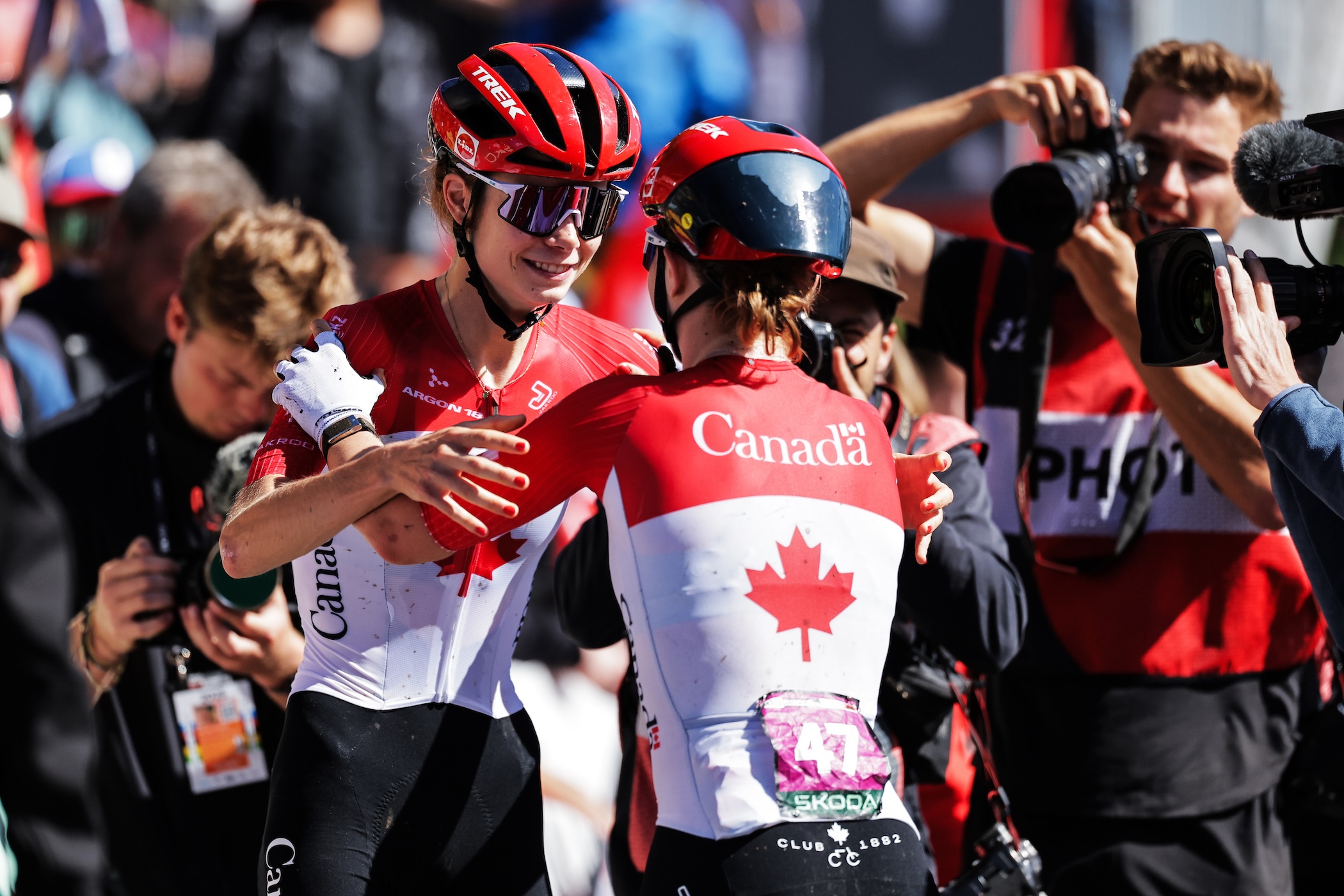En el Campeonato Mundial de Ciclismo de Montaña UCI 2025 para Canadá, Isabella Holmgren (a la izquierda) celebra una victoria en la carrera XCO U23 con un abrazo de su hermana Ava.