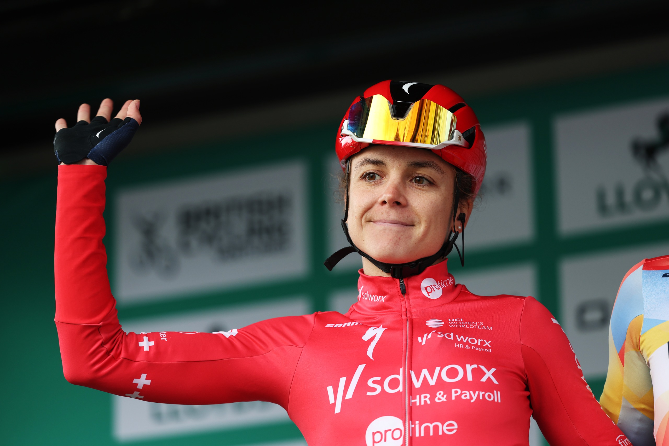 Steffi Häberlin saluda a los aficionados en el escenario antes de la etapa 1 del Tour de Gran Bretaña Femenino 2026